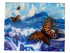 Butterflies flying across the ocean to Mexico. Blue waters are depicted with hand painted butterflies.