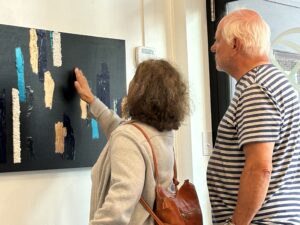 a woman touching the art at the Quinte Arts Council exhibit