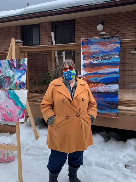 Lynda standing in front art piece at an outdoor Peterborough exhibit during covid.