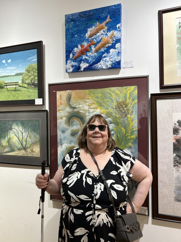 Lynda Todd standing in front the Salmon piece at the Chinese Art Exhibit